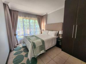 a bedroom with a large bed and a window at Margate Manor in Pretoria