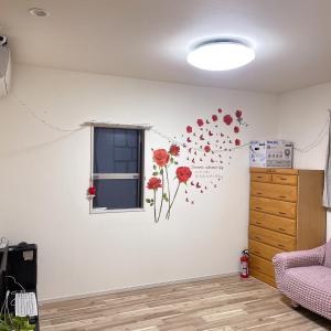 a room with red flowers on the wall at MiShe主题民宿 in Tokyo