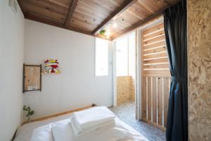 a bedroom with a bed and a large window at Kotori Coworking & Hostel Kotohira in Kotohira