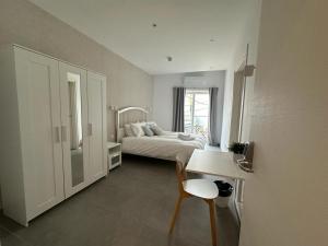 a bedroom with a bed and a table and a desk at Gest in Mellieħa