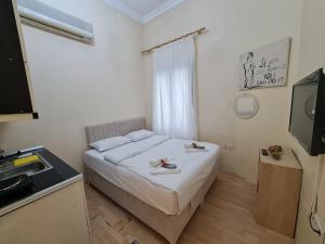 Dormitorio pequeño con cama y TV en Perla di Pera Hotel, en Estambul