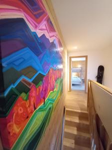 Una habitación con un mural colorido en la pared. en LE ZÈDÈL - Duplex 100m2 vue montagne, au cœur de la Savoie, au pied des stations de ski, en Aigueblanche