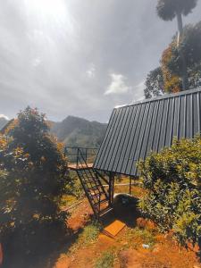 una casa con techo de metal en un campo en Papathi farm house en Kodaikānāl