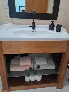 a bathroom vanity with a sink with towels and a mirror at SaberAmar City & Ria & More in Aveiro