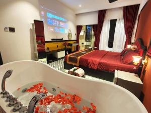 een badkamer met een bad en een slaapkamer bij Punita Hotel in Dien Ban