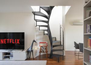 A television and/or entertainment centre at Giresio 41 - Your Penthouse with Rooftop Garden in Milano Navigli - WIFI