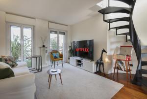 A television and/or entertainment centre at Giresio 41 - Your Penthouse with Rooftop Garden in Milano Navigli - WIFI