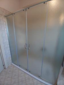 La salle de bains est pourvue d'une cabine de douche avec des portes en verre. dans l'établissement B&B la Casa Giusotto, à Giulianova