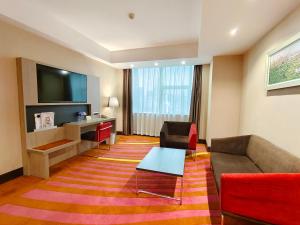 a hotel room with a couch and a table and a television at Shenzhen Novotel Watergate(Kingkey 100) in Shenzhen