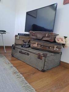 a stack of suitcases with a tv on top at SaberAmar City & Ria & More in Aveiro