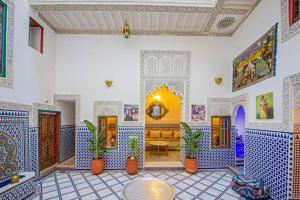 a living room with blue and white tiles on the walls at Riad Rayhana in Fès