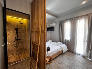 a bedroom with a shower and a bed and a bathroom at Orfeas Luxury Rooms & Studio in Skopelos Town