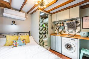 um quarto com uma cama e uma máquina de lavar e secar roupa em Shanghai Hills&XING 372 Homestay em Xangai