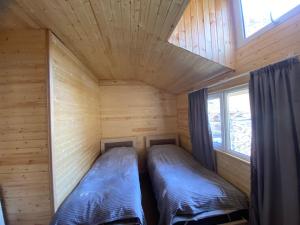 two beds in a log cabin with a window at Guesthouse Shete 
