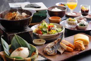 una mesa con platos de comida y tazones de comida en Ako Onsen Shokichi, en Ako