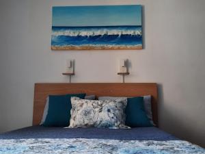 a bedroom with a bed with a painting on the wall at Estudio coqueto Torres del Sol in Arona +20 photos