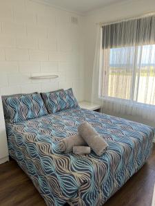 a bedroom with a bed with a teddy bear on it at Edithburgh Foreshore Apartments in Edithburgh