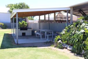 a picnic shelter with a picnic table in a yard at Edithburgh Foreshore Apartments in Edithburgh