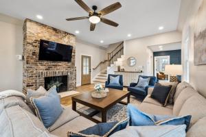 a living room with couches and a fireplace at Tranquil Mountain Escape Luxurious 5-Bedroom Farmhouse with Pool in Maryville