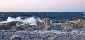 - une plage avec des rochers et des vagues dans l'océan dans l'établissement Fantastiskt hus på fårö, à Fårö