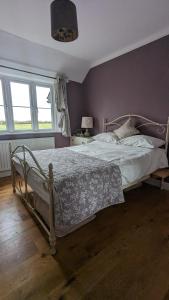 a bedroom with a large bed with a wooden floor at Cosy family cottage south Somerset in Long Sutton