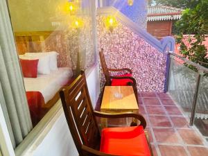 a balcony with two chairs and a table and a bed at Coral Beach Hotel in Mirissa