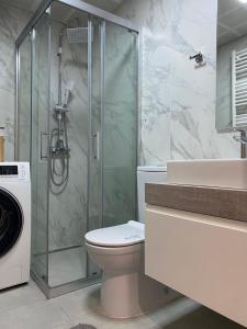 y baño con ducha, aseo y lavamanos. en Urban LEKS apartment, en Skopje
