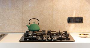 a green tea kettle sitting on top of a stove at Nel cuore di Oristano in Oristano