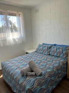 a bed with a stuffed animal on top of it at Edithburgh Foreshore Apartments in Edithburgh