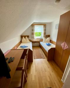 ThalheimにあるGasthof Widenschekのベッド2台とテーブルが備わる小さな客室です。