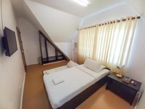 Habitación pequeña con cama y ventana en Castle Rock Apartelle en Boracay