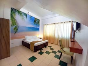 ein Schlafzimmer mit einem Bett mit einem Palmenmilch an der Wand in der Unterkunft Castle Rock Apartelle in Boracay