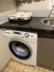 eine Waschmaschine in einer Küche neben einer Spüle in der Unterkunft COSY STUDIO PARIS LA DÉFENSE in Courbevoie