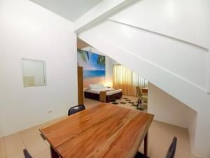 a dining room with a table and a bed at Castle Rock Apartelle in Boracay