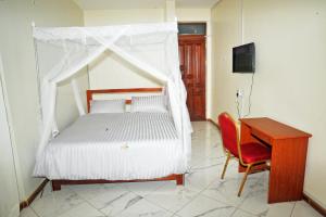 Un pat sau paturi într-o cameră la Apollo Inn Fortportal