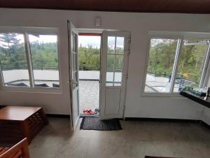 a room with a door and windows with a balcony at Silver Spruce Glass Villa 1BHK Kotagiri in Kotagiri
