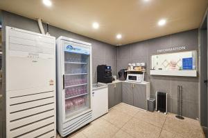 a kitchen with an open refrigerator and a microwave at Urban Hotel 