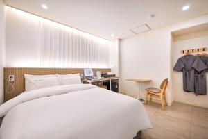 a bedroom with a large white bed and a desk at Urban Hotel 