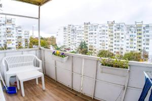 Un balcón con una silla blanca y dos macetas. en Alex Botique en Varna