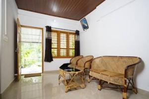 Entire Private Guest House Munnar في مونار: غرفة بها كراسي وطاولة ونافذة