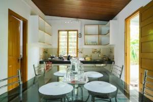 una cocina con 2 mesas y sillas y una barra en Entire Private Guest House Munnar, en Munnar