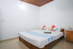 Cama en habitación con pared blanca en Entire Private Guest House Munnar en Munnar
