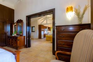 a bedroom with a bed and a dresser and a mirror at Solaris Methea Deluxe Suites in Kassiopi