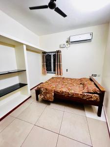 Schlafzimmer mit einem Bett und einem Deckenventilator in der Unterkunft Lumina Home Stay in Puducherry