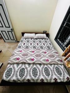 ein Bett mit einer Decke in einem Schlafzimmer in der Unterkunft Lumina Home Stay in Puducherry