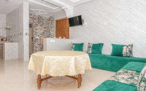 a living room with a green couch and a table at Imsouane Wave Residences in Imsouane