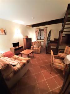 ein Wohnzimmer mit einem Sofa und einem Tisch in der Unterkunft La Galamperna in Nava del Barco