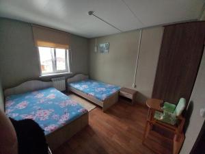 バイカリスクにあるApartmentsのベッド2台と椅子が備わる小さな客室です。