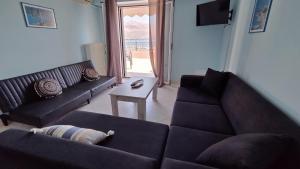 a living room with two couches and a table at Johanna Sea View Apartment in Lixouri +10 photos