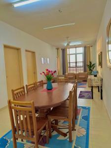 a dining room with a wooden table and chairs at Normanis Homestay in Kota Bharu